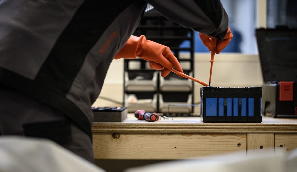 Technician wearing safety gloves during battery maintenance
